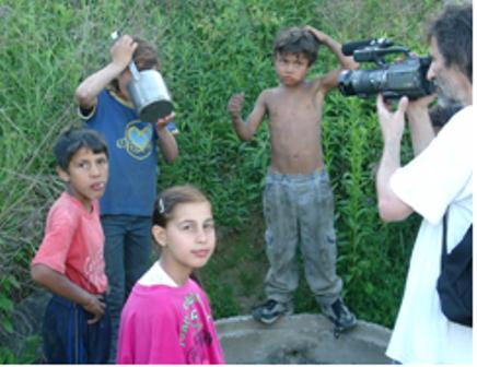 Hairdresser Miodrag Misa is filming 
                                the children at the standpost Hairdresser Miodrag Misa is filming
                                the children at the standpost